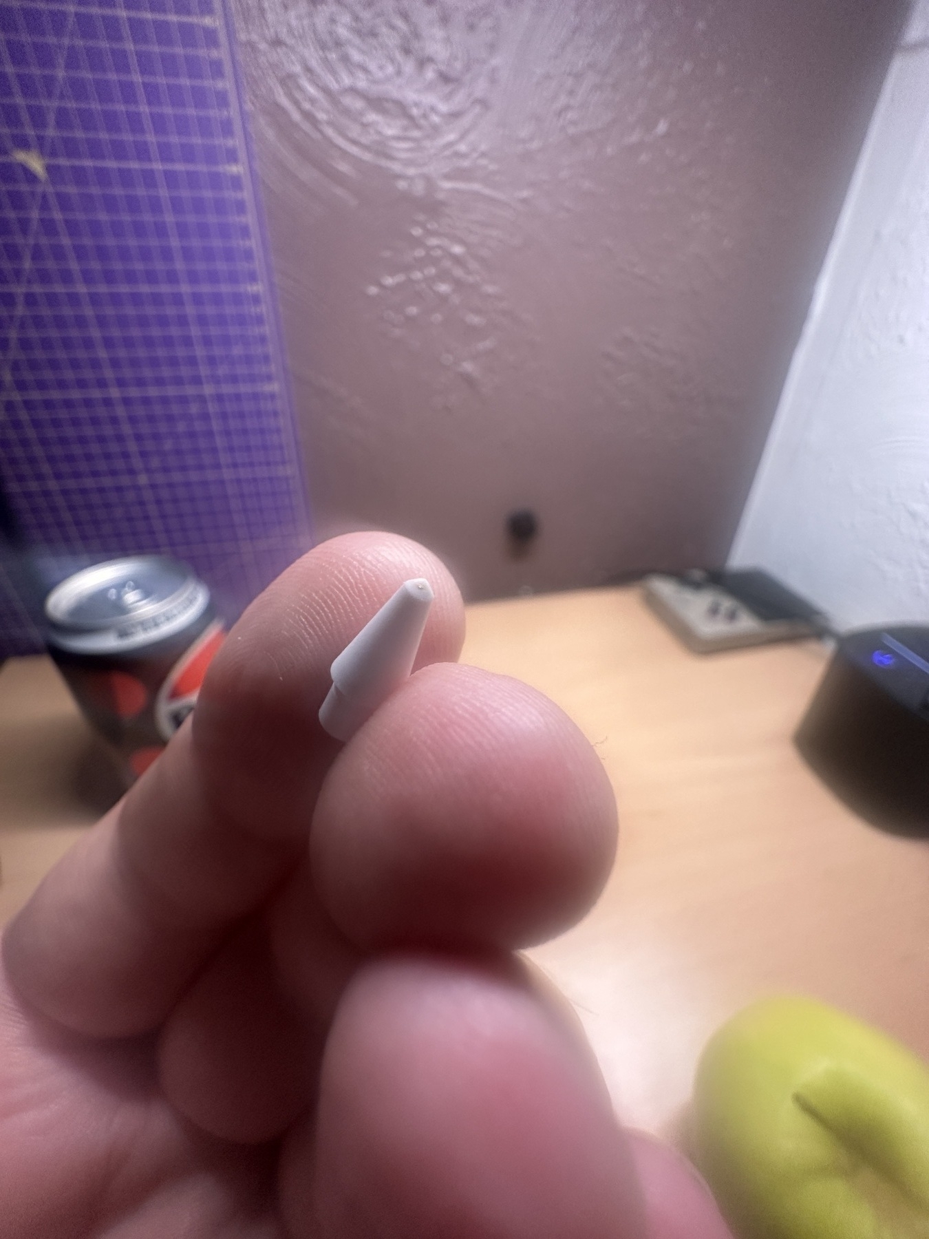 Close-up of a worn out Apple Pencil tip showing some copper through a white edge